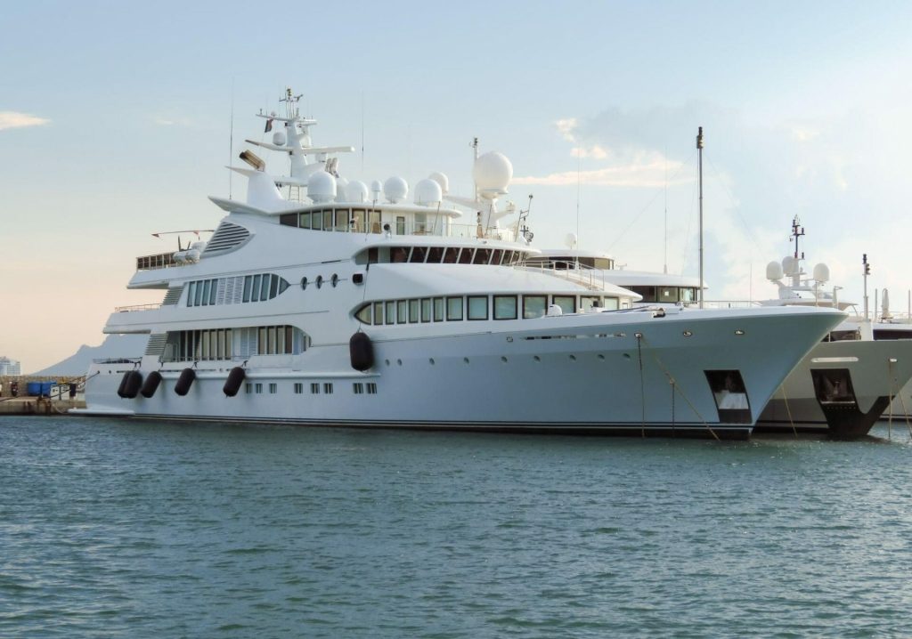 Large white luxury yacht docked in water
